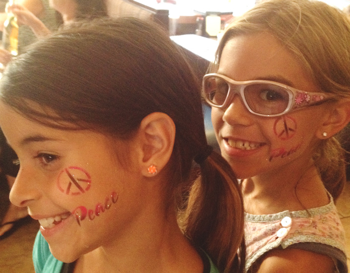airbrush face painted girls with peace symbols